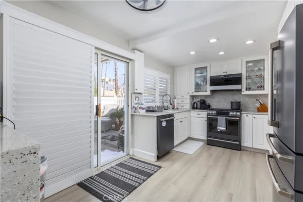 a kitchen with stainless steel appliances granite countertop a stove a sink and a refrigerator