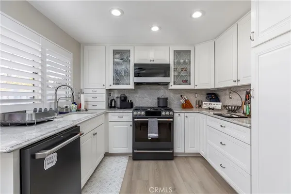 a kitchen with stainless steel appliances granite countertop a stove sink and cabinets