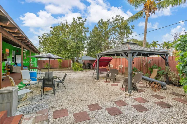 a view of a patio with a table and chairs under an umbrella