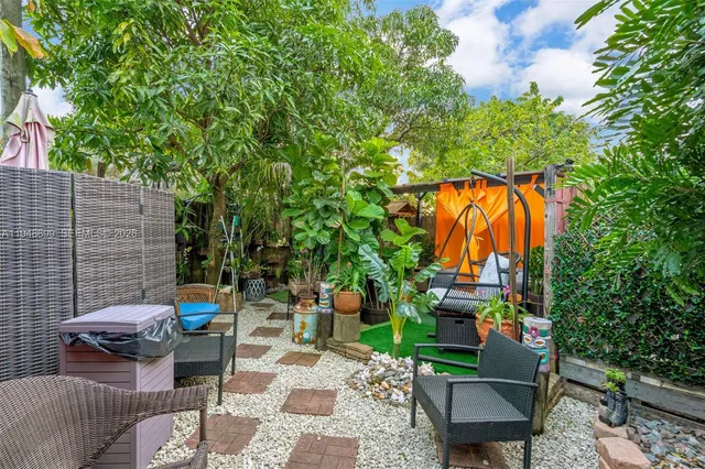a backyard of a house with barbeque oven table and chairs