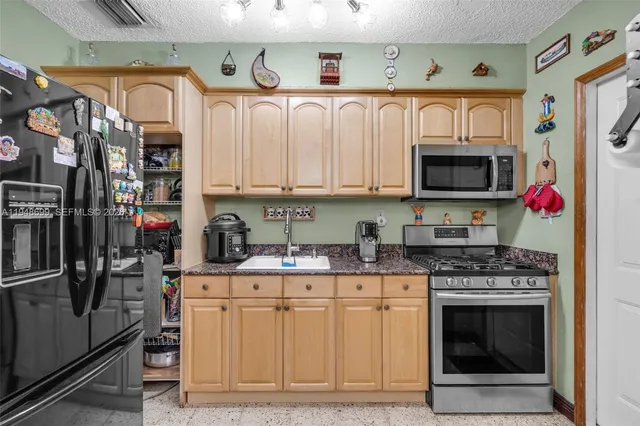 a kitchen with stainless steel appliances granite countertop a stove top oven a sink and dishwasher