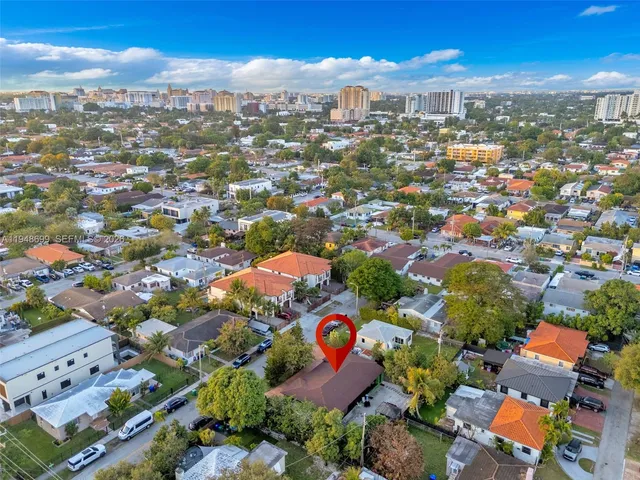 an aerial view of residential houses with outdoor space and trees
