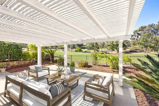 a living room with patio furniture and a garden
