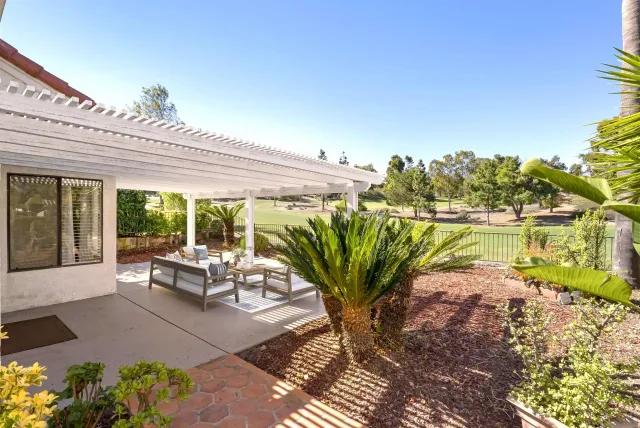 a view of a porch with furniture and a yard