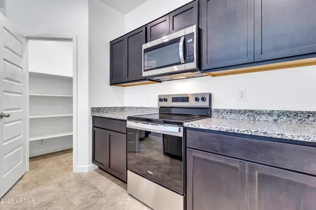 a kitchen with stainless steel appliances granite countertop a sink and a microwave