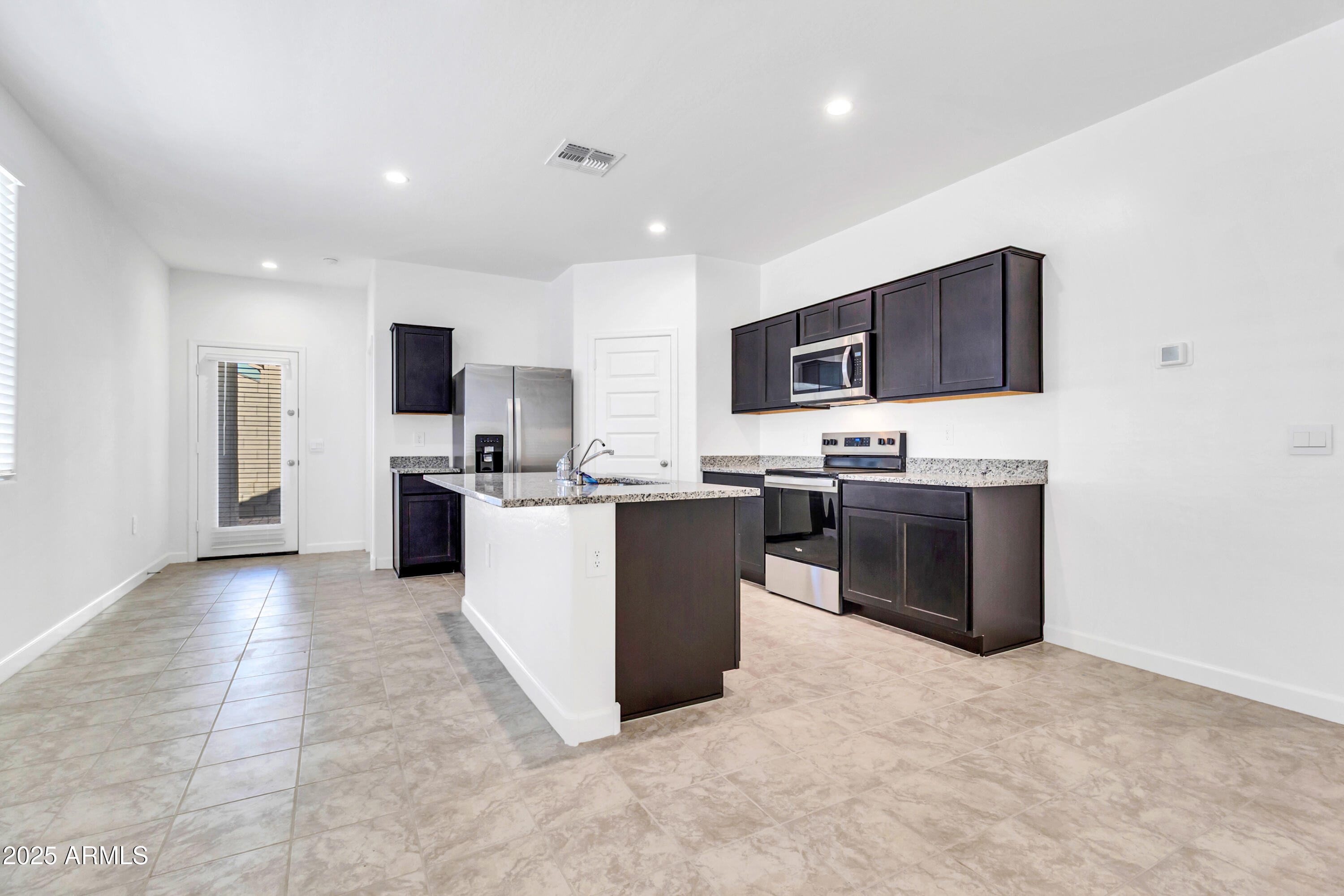 2108 West Sheridan Avenue Apache Junction, AZ 85120 - Photo 14 of 49 a kitchen with kitchen island a sink a stove a microwave a counter top space and cabinets
