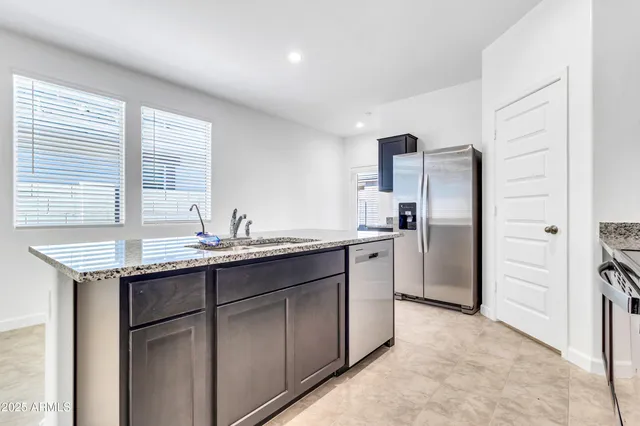 a kitchen with stainless steel appliances granite countertop a refrigerator and a sink