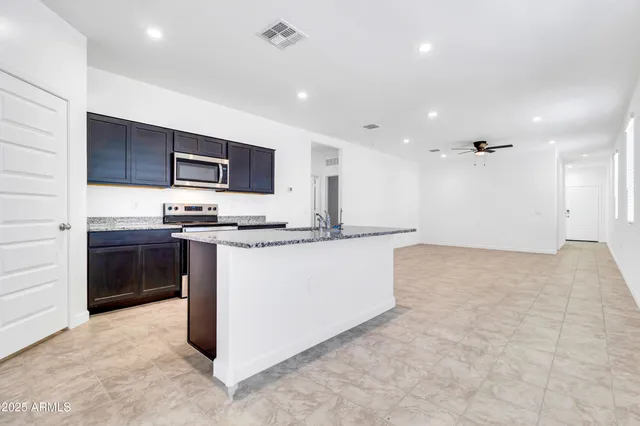 a kitchen with kitchen island a sink stainless steel appliances and cabinets