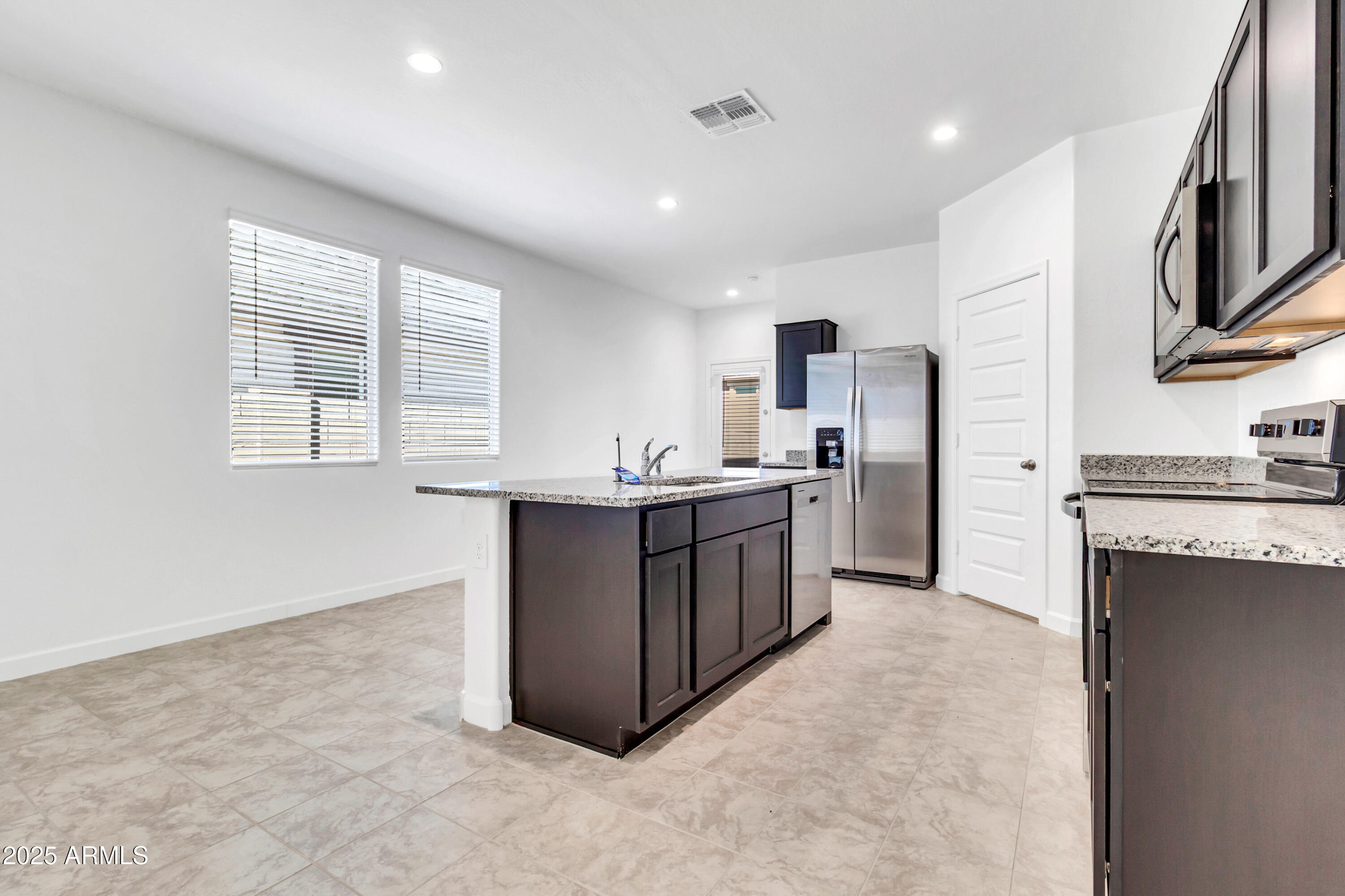2108 West Sheridan Avenue Apache Junction, AZ 85120 - Photo 18 of 49 a kitchen with stainless steel appliances granite countertop a stove a sink a refrigerator and a microwave
