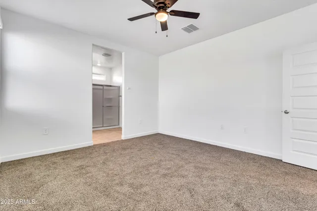 an empty room with chandelier fan