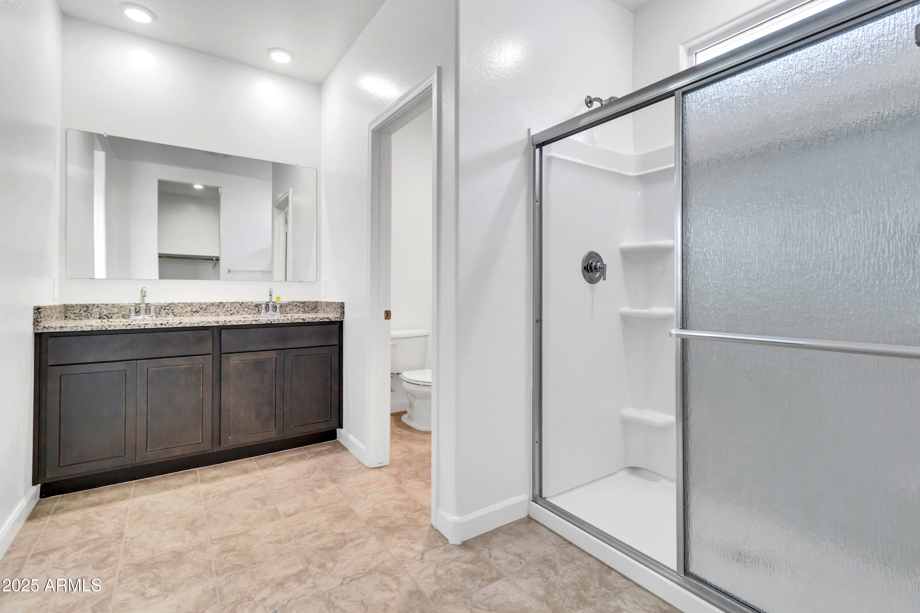 2108 West Sheridan Avenue Apache Junction, AZ 85120 - Photo 25 of 49 a bathroom with a granite countertop sink a mirror and a shower