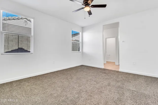 an empty room with a window and a fan