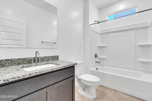 a bathroom with a granite countertop sink a toilet and bathtub
