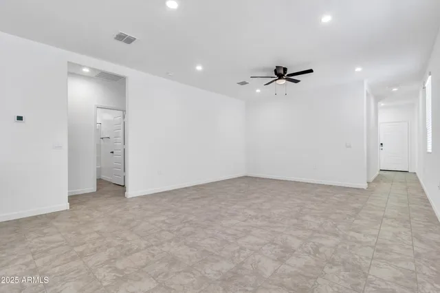 an empty room with fan and windows