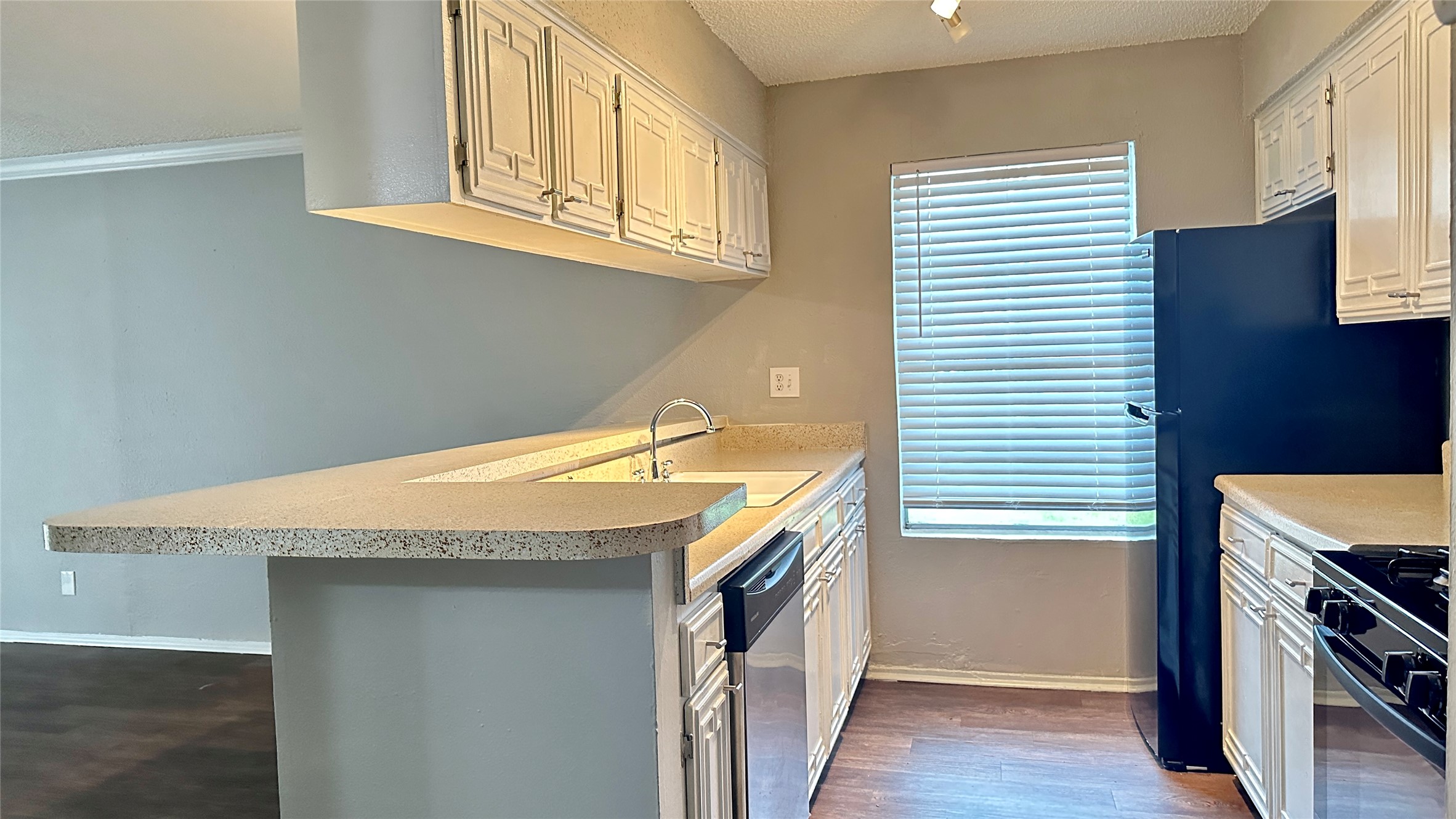 5426 Menchaca Road, Unit 119 Austin, TX 78745 - Photo 8 of 8 Kitchen featuring white cabinetry, light-colored countertops, and dark wood-finish flooring