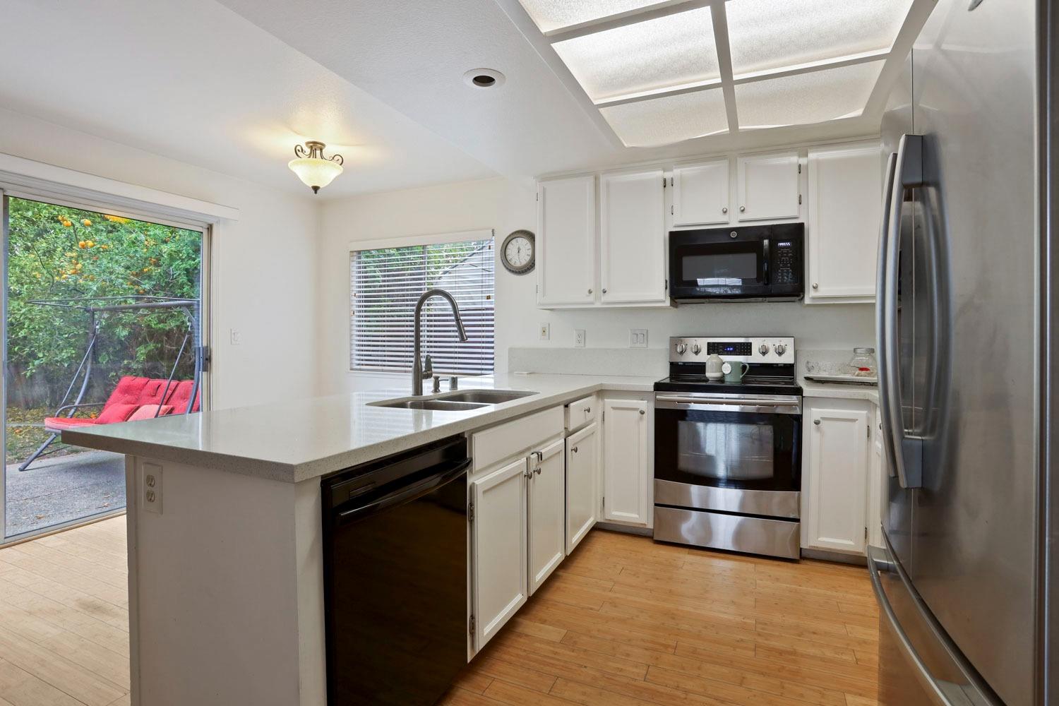 145 Machado Court Tracy, CA 95376 - Photo 12 of 28 a kitchen with stainless steel appliances kitchen island granite countertop a refrigerator and a sink