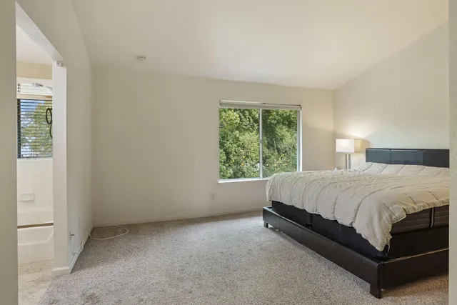 a bed sitting in a bedroom next to a window