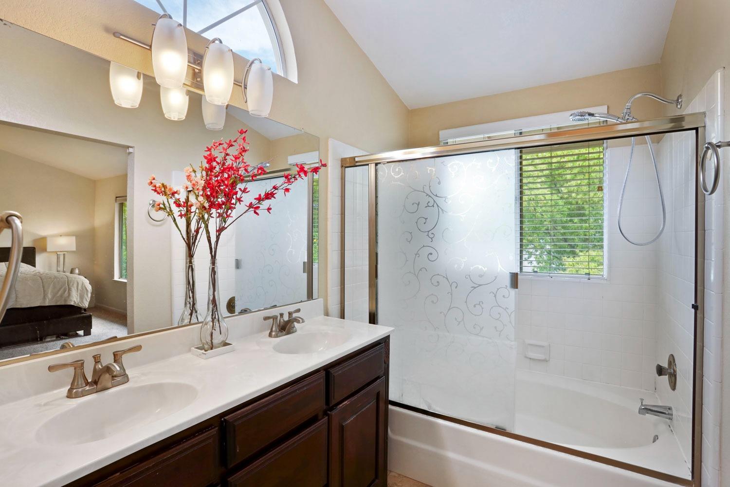 145 Machado Court Tracy, CA 95376 - Photo 21 of 28 a bathroom with a granite countertop sink a shower and a mirror