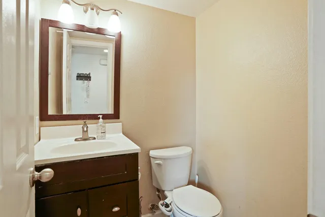 a bathroom with a toilet sink and mirror