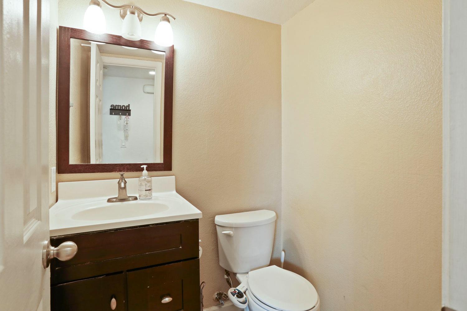 145 Machado Court Tracy, CA 95376 - Photo 23 of 28 a bathroom with a toilet sink and mirror