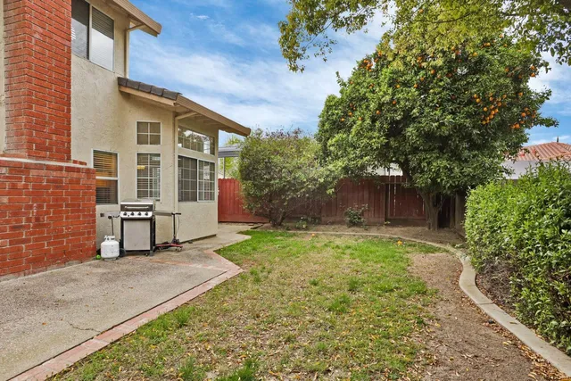 a view of a house with backyard and a tree