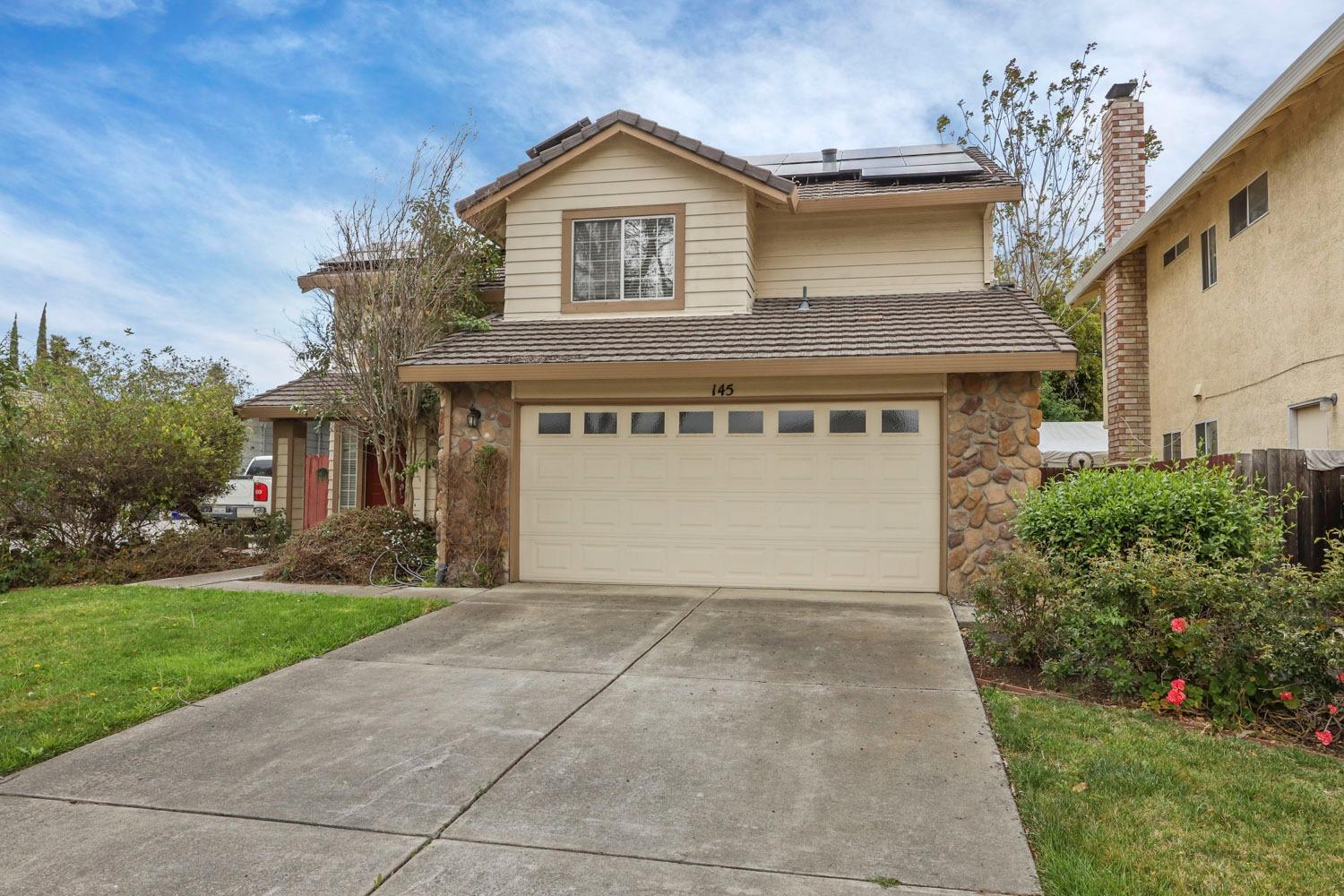 145 Machado Court Tracy, CA 95376 - Photo 4 of 28 a front view of a house with a yard and garage