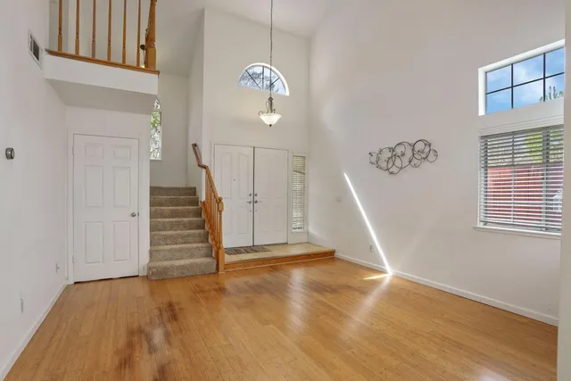 a view of a livingroom with wooden floor and stairs