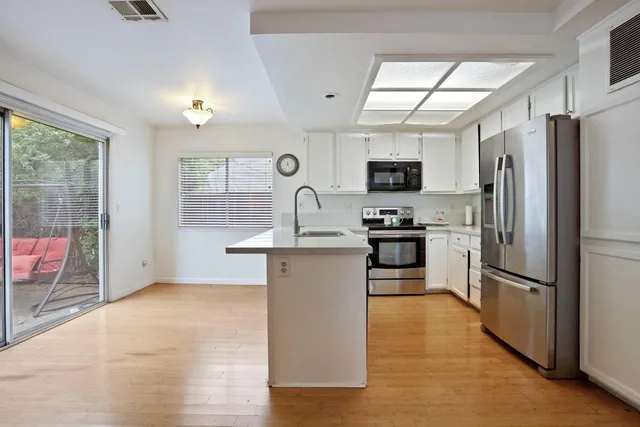 a kitchen with granite countertop a refrigerator stove top oven and sink