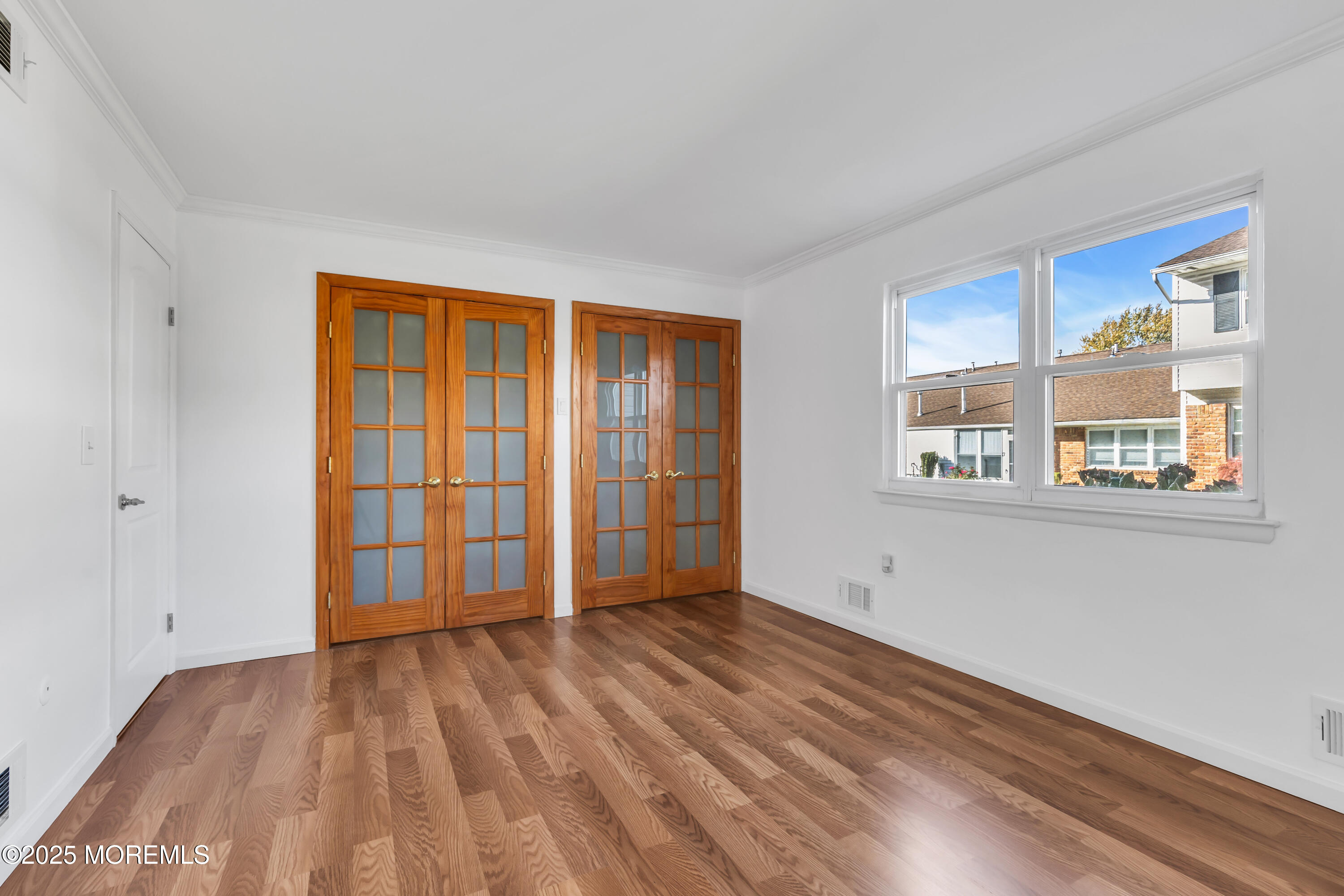 5 Indiana Court, Unit A Matawan, NJ 07747 - Photo 15 of 32 a view of an empty room with wooden floor and a window