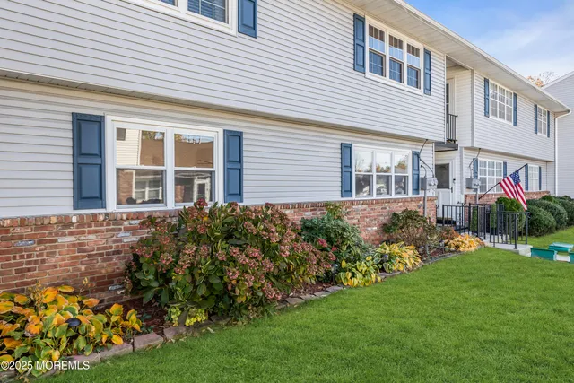 a front view of a house with a garden and plants