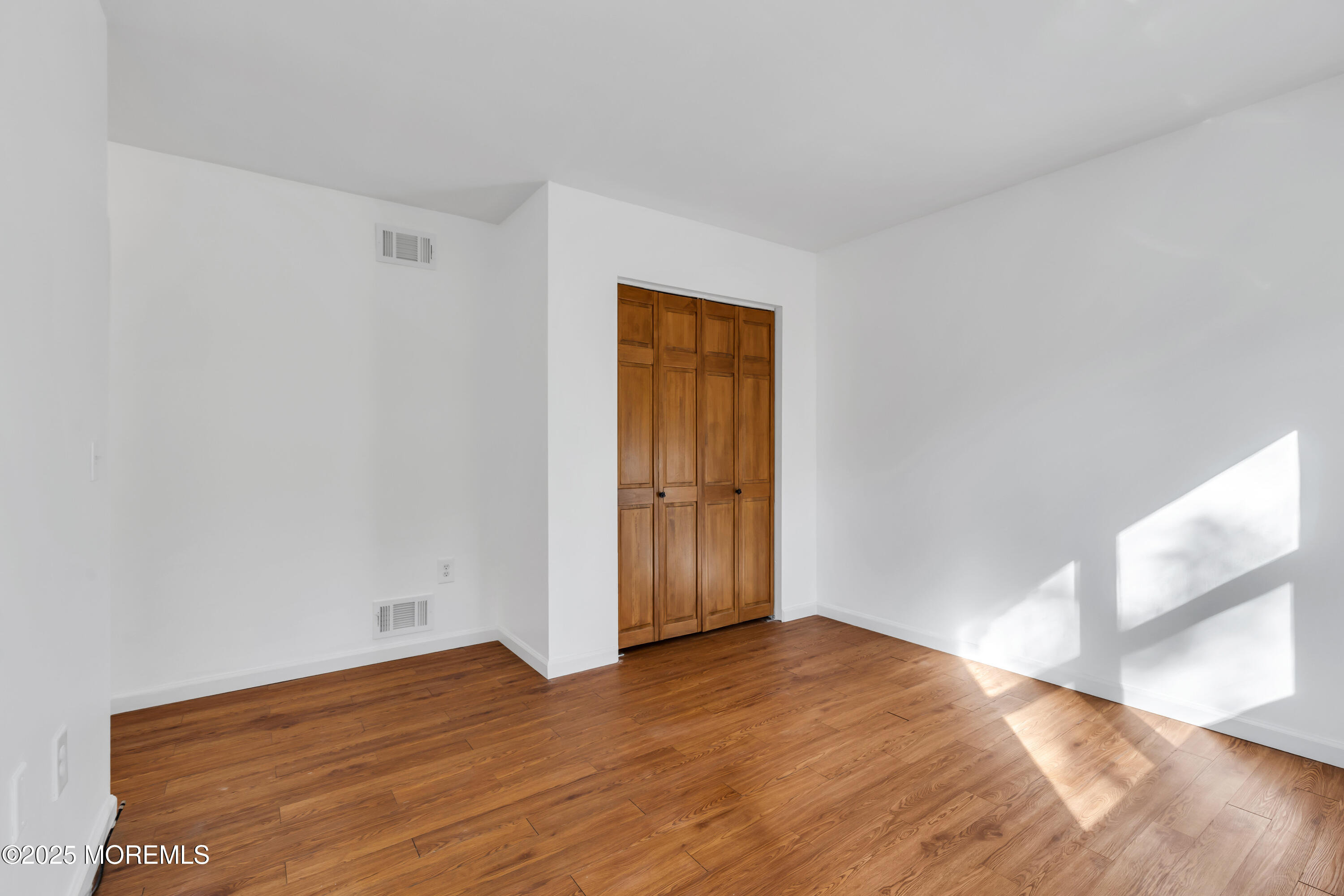 5 Indiana Court, Unit A Matawan, NJ 07747 - Photo 21 of 32 a view of empty room with wooden floor and fan