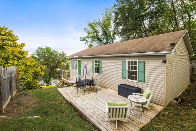 a view of a patio with table and chairs with wooden floor and fence