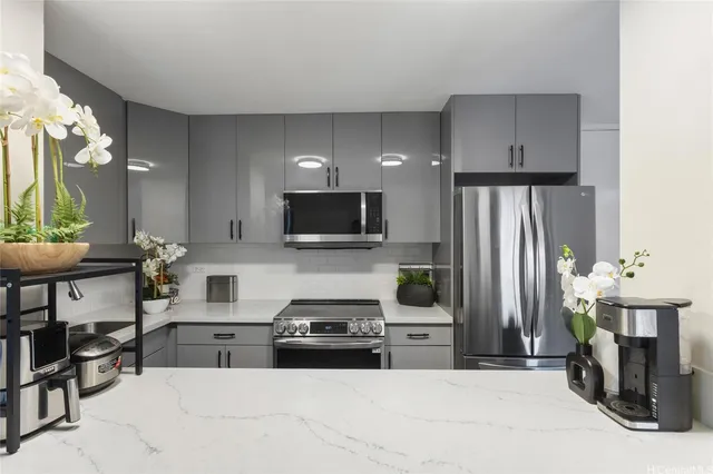 a kitchen with stainless steel appliances a stove a sink a microwave a refrigerator and cabinets