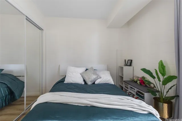 a bedroom with a bed and potted plant