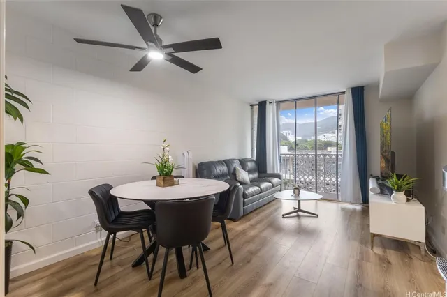 a dining room with furniture potted plants and wooden floor
