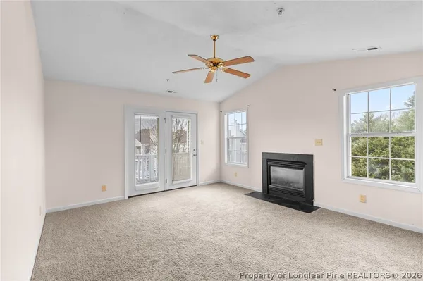 a view of a livingroom with a fireplace and window