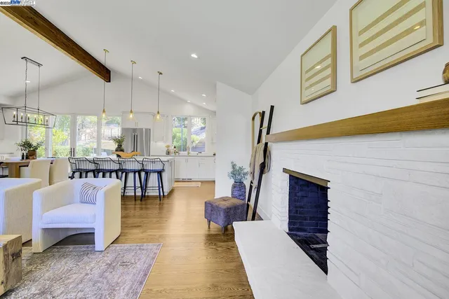 a kitchen with stainless steel appliances kitchen island granite countertop a table chairs sink and cabinets