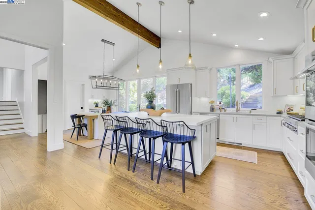 a kitchen with kitchen island a stove a table and chairs