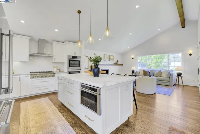 a view of living room with kitchen island furniture and a chandelier