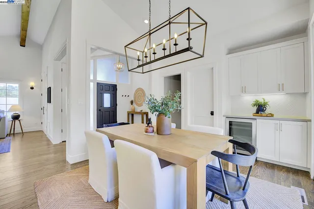 a dining room filled chandelier and wooden floor