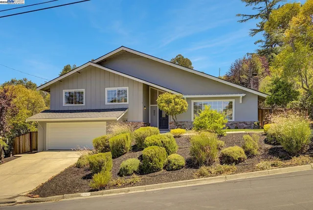 an aerial view of residential houses with outdoor space and trees