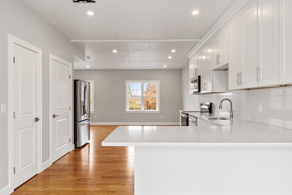 10 Windsor Street Worcester, MA 01605 - Photo 9 of 26 a large kitchen with stainless steel appliances granite countertop a sink and cabinets