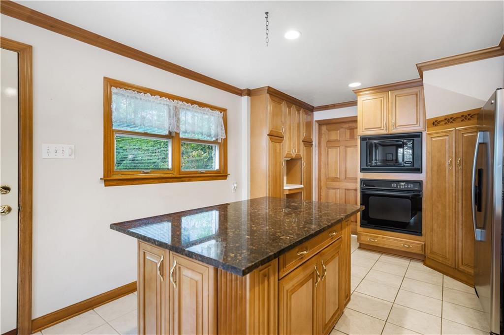 111 Siebert Road Pittsburgh, PA 15237 - Photo 12 of 25 a kitchen with stainless steel appliances granite countertop a refrigerator a stove and a sink with wooden floor