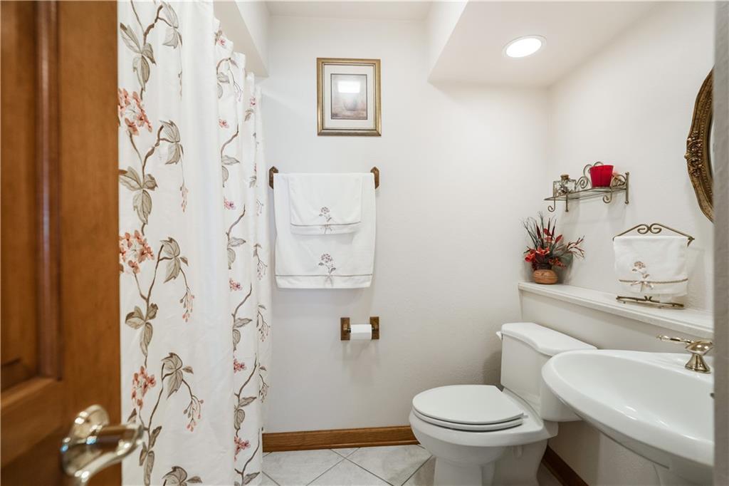 111 Siebert Road Pittsburgh, PA 15237 - Photo 13 of 25 a white toilet sitting next to a bathroom sink and a mirror