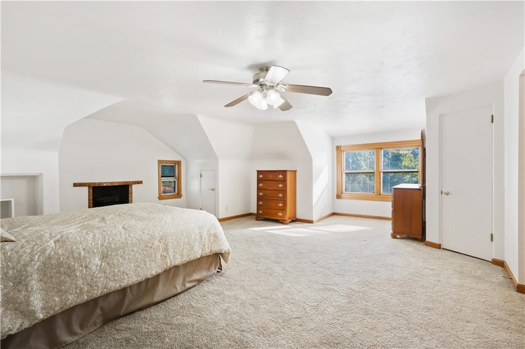 111 Siebert Road Pittsburgh, PA 15237 - Photo 14 of 25 a spacious bedroom with a large bed a chandelier and fireplace