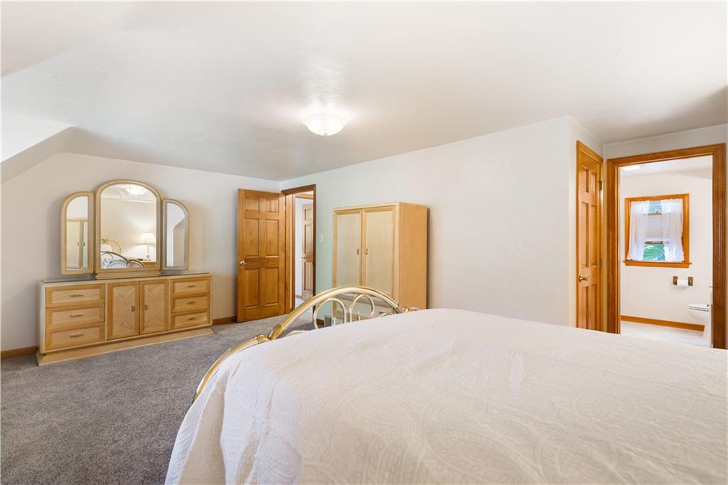 111 Siebert Road Pittsburgh, PA 15237 - Photo 19 of 25 a bedroom with a large bed and dresser with mirror