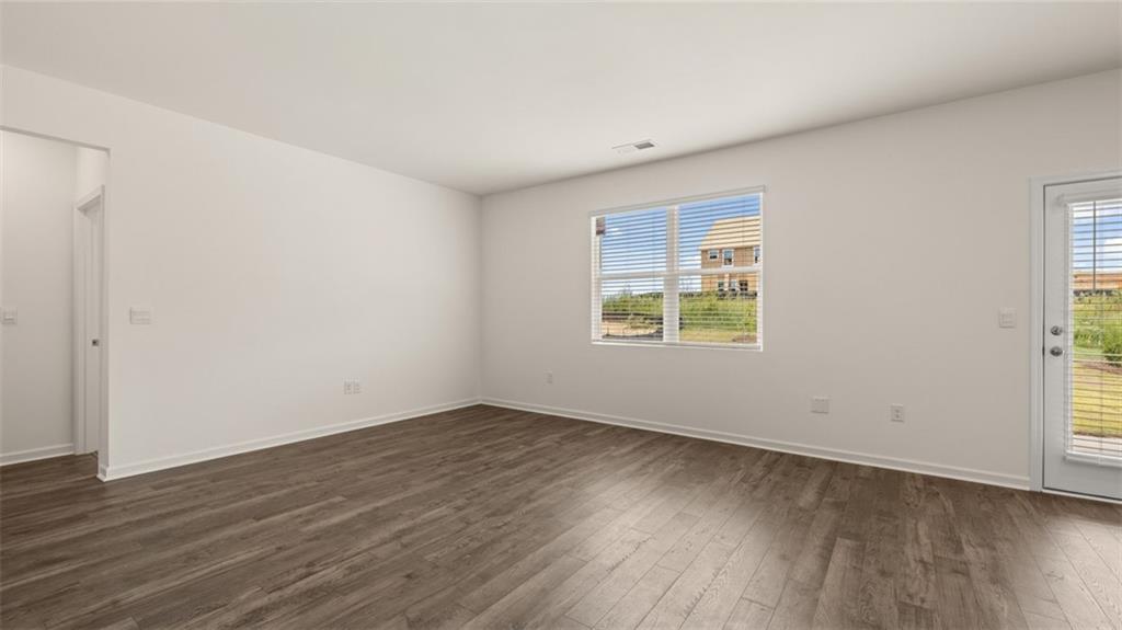 212 Cattle Drive Perry, GA 31069 - Photo 11 of 40 an empty room with wooden floor and windows
