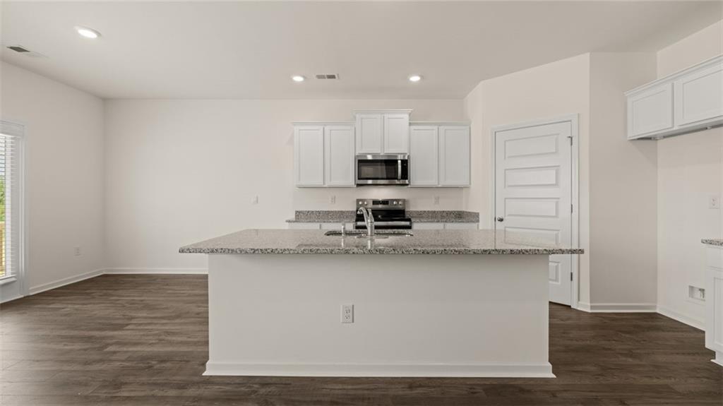 212 Cattle Drive Perry, GA 31069 - Photo 7 of 40 a kitchen with stainless steel appliances a sink stove and cabinets