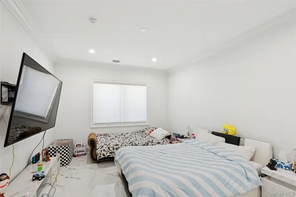 a bedroom with a bed a couch and a flat screen tv