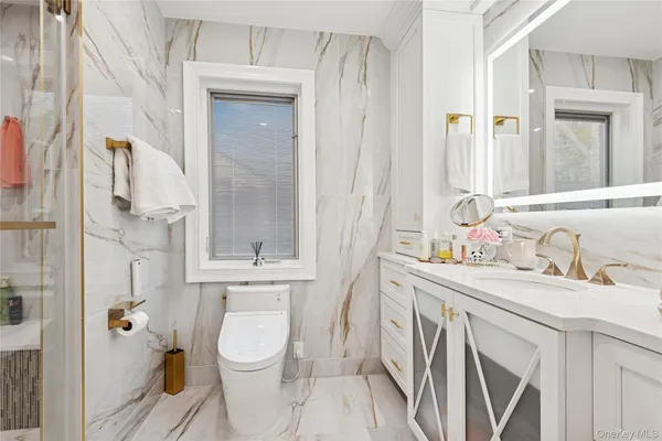 a bathroom with a granite countertop sink a toilet and a shower